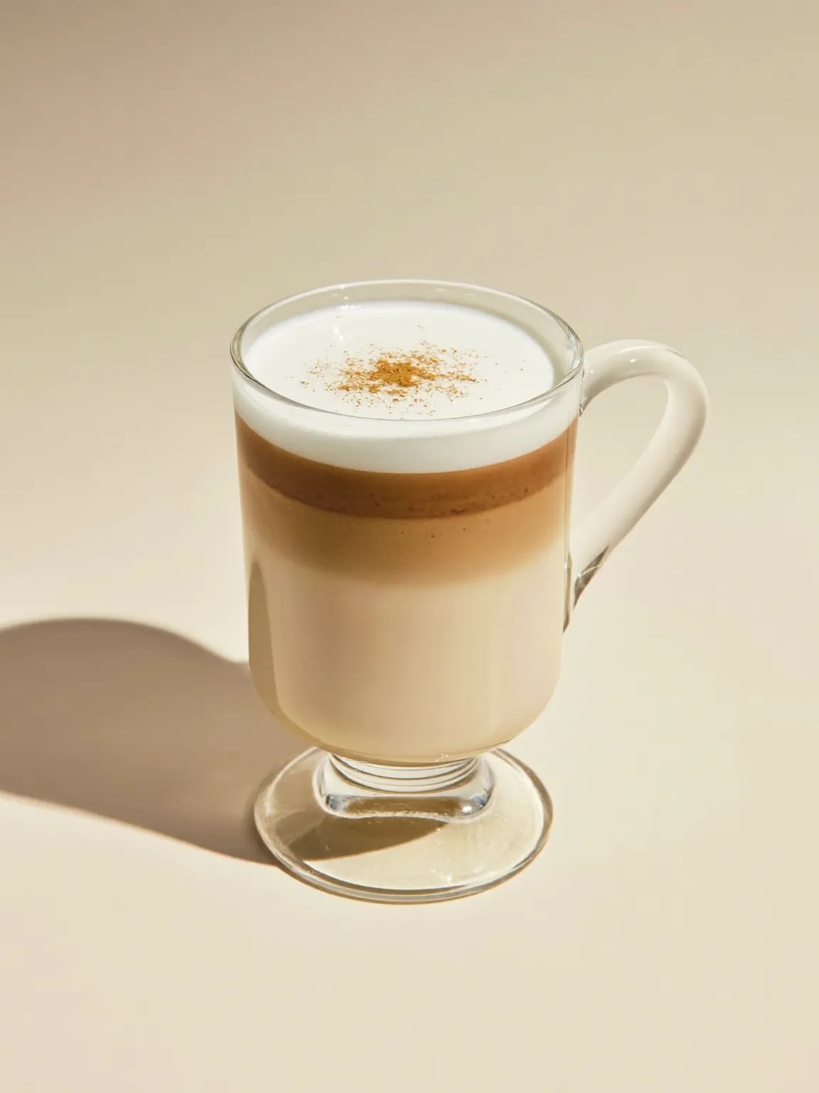 A spiced chai latte in a glass mug